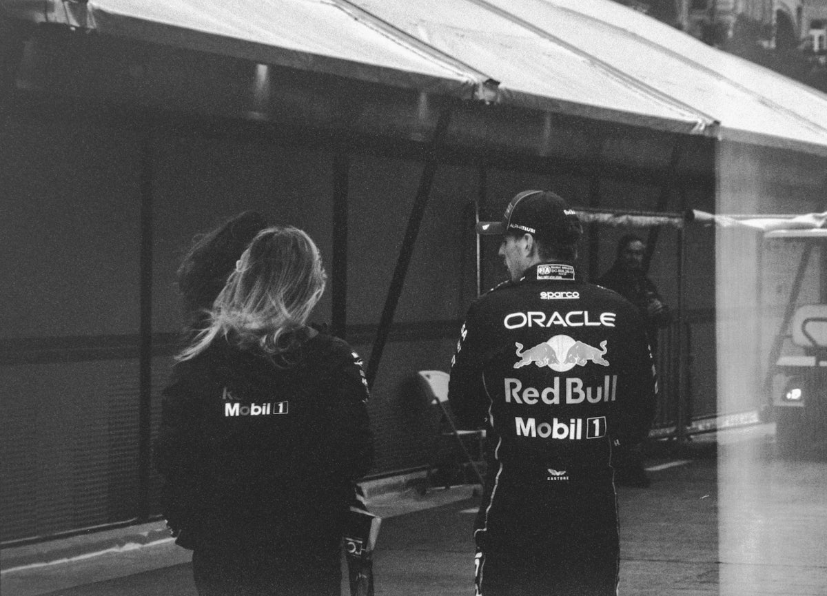 Two people in red bull racing jackets near tent