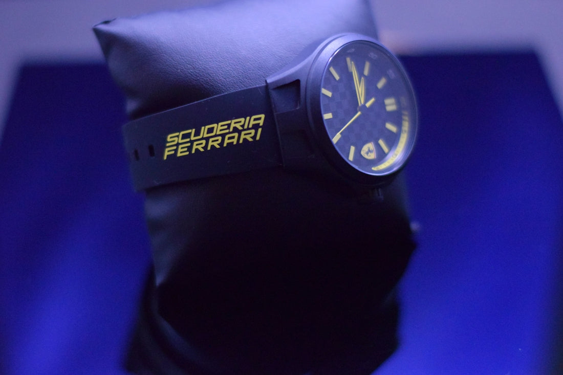 Scuderia ferrari watch on display with blue lighting.